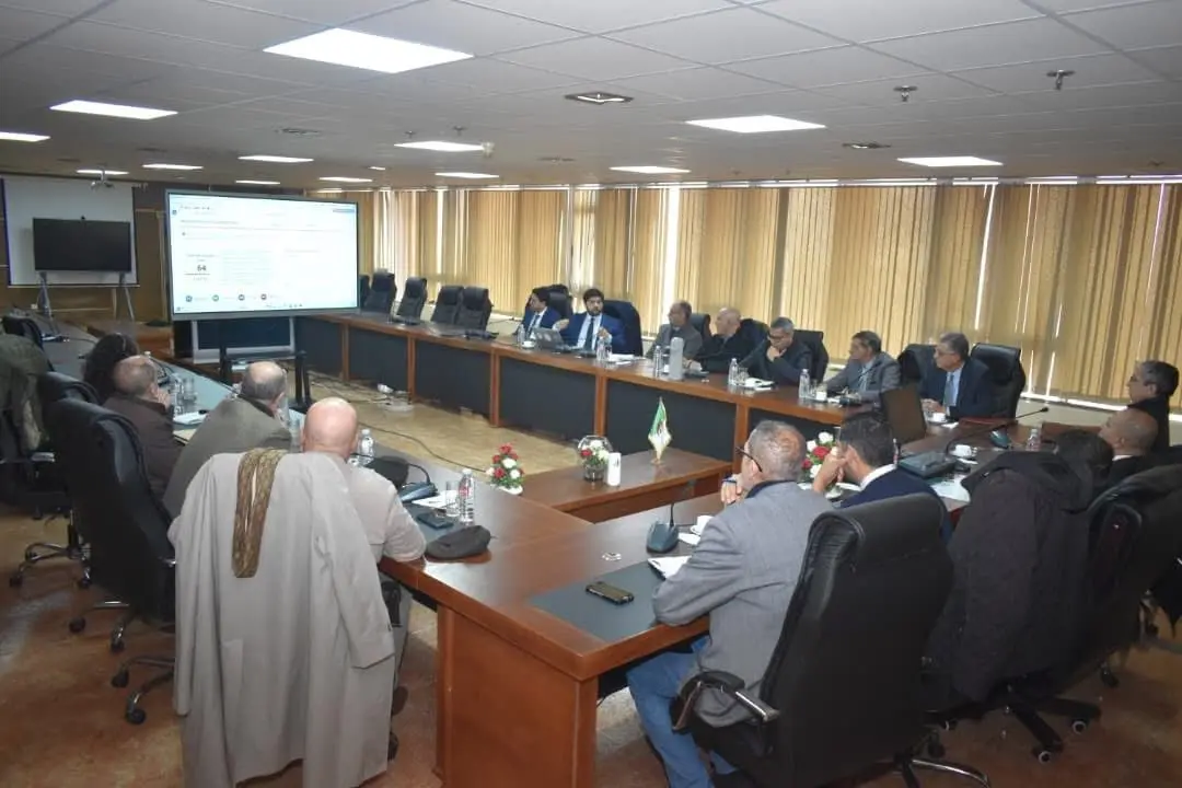 Presentation of digital education solutions to USTO-MB leaders gathered around the working table.
